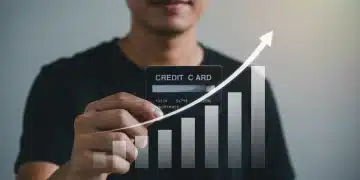 Smiling person holding credit card with rising FICO score graph